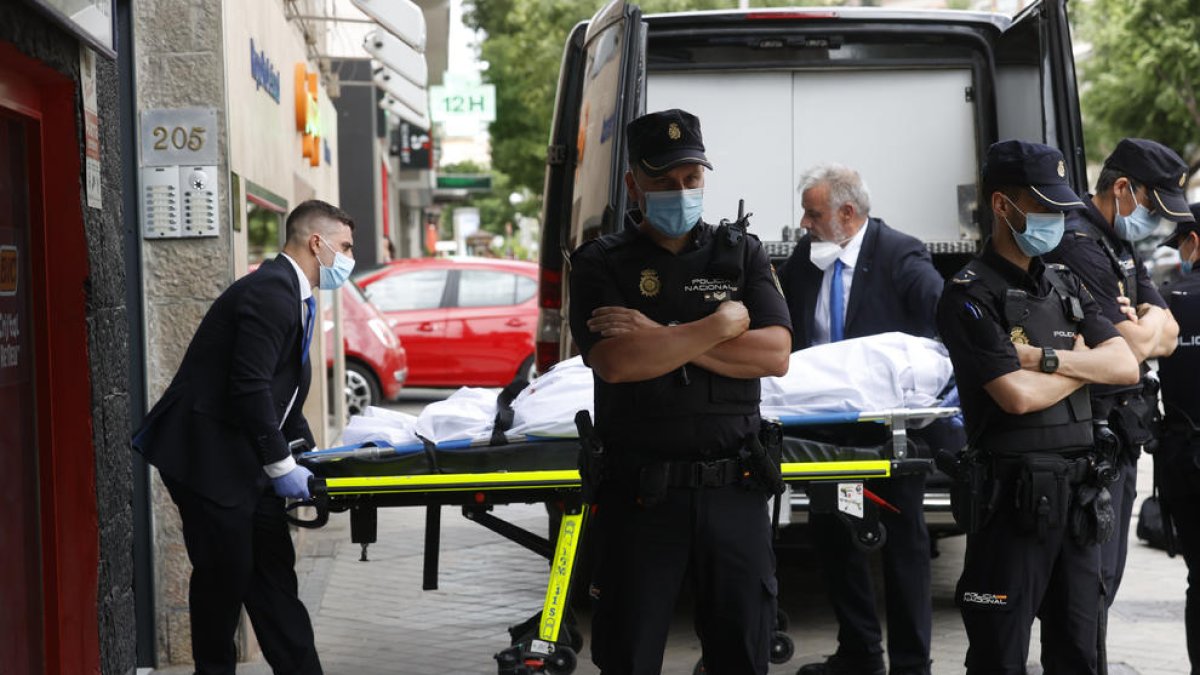 Membres del servei funerari traslladen un dels tres cadàvers.
