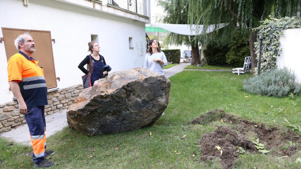 Tres vecinos de Rialp ayer junto a la gran roca que se desprendió el lunes al lado de la gasolinera.