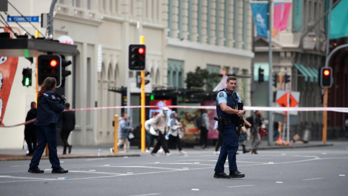 Policías hacen guardia en un área acordonada cerca del lugar de un tiroteo en Queen Street, Auckland, Nueva Zelanda.