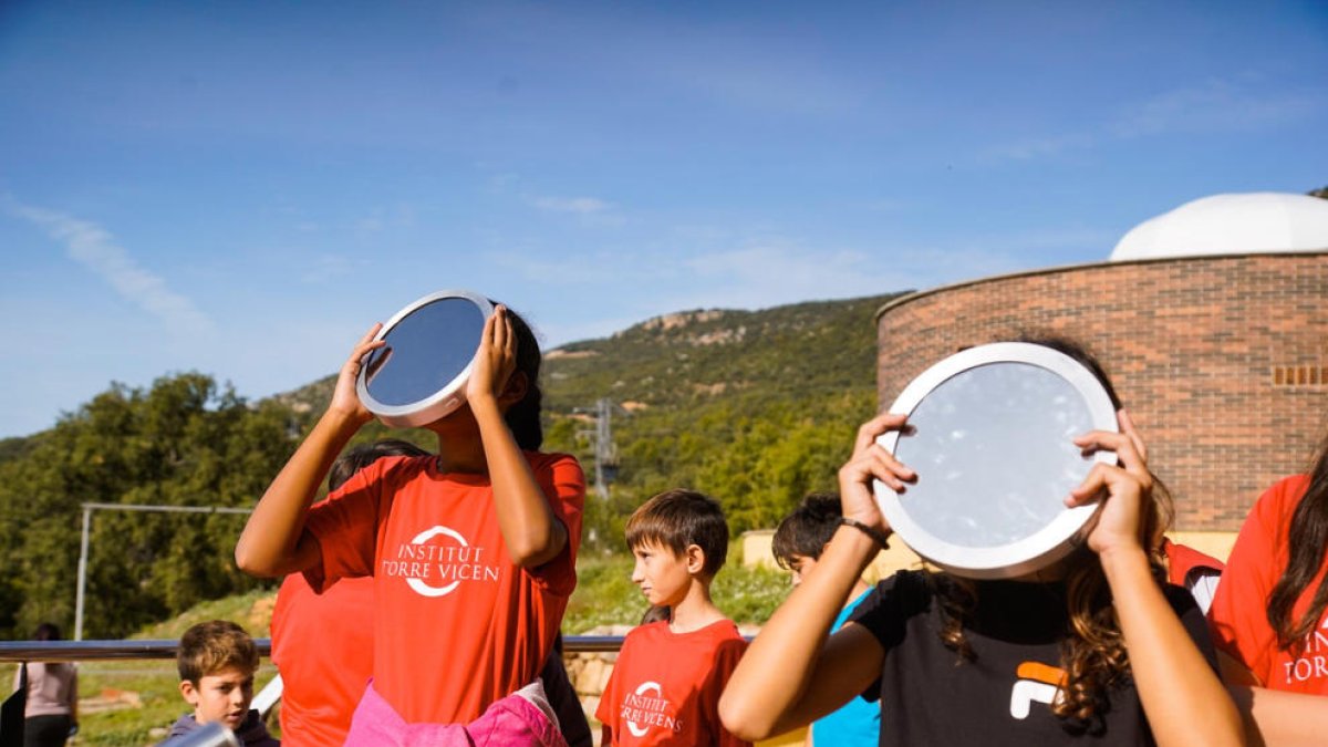 Alumnos del instituto Maria Rúbies (izquierda) pudieron observar el fenómeno en el patio y los del Torre Vicens (derecha) se desplazaron al Parc Astronòmic del Montsec.