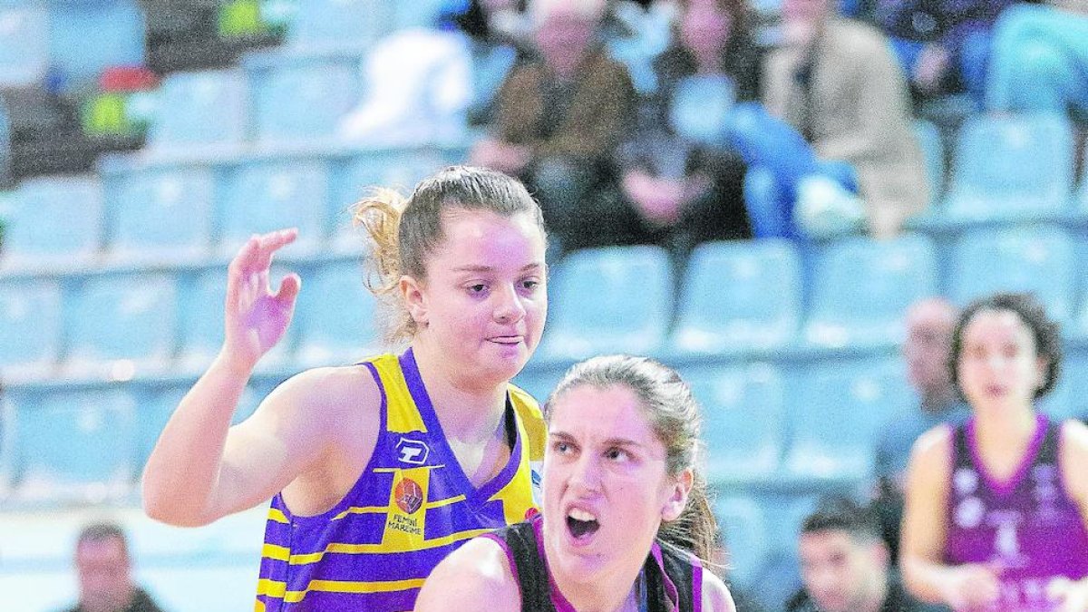 Iris Tribó intenta una entrada a cistella pressionada per una rival.