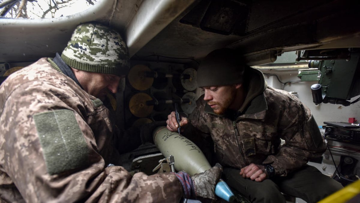 Militars ucraïnesos firmen un projectil des de l’interior d’un obús autopropulsat a Donetsk.