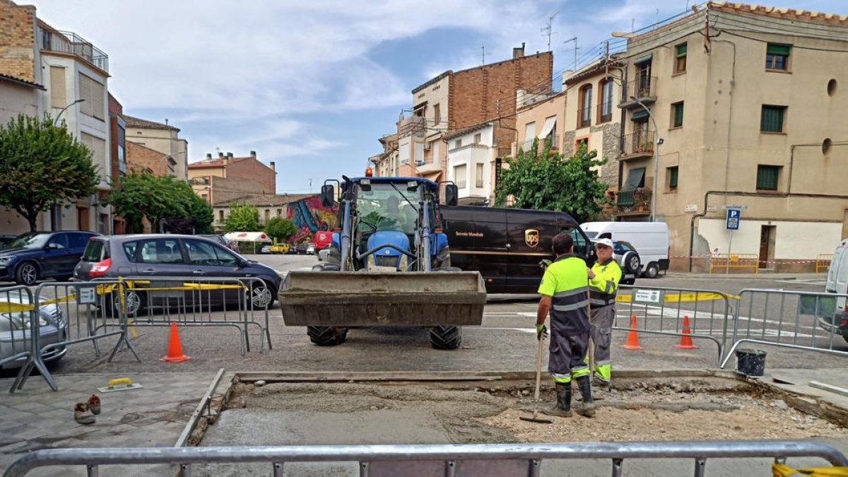 La brigada treballant per eliminar el sorral de la plaça.