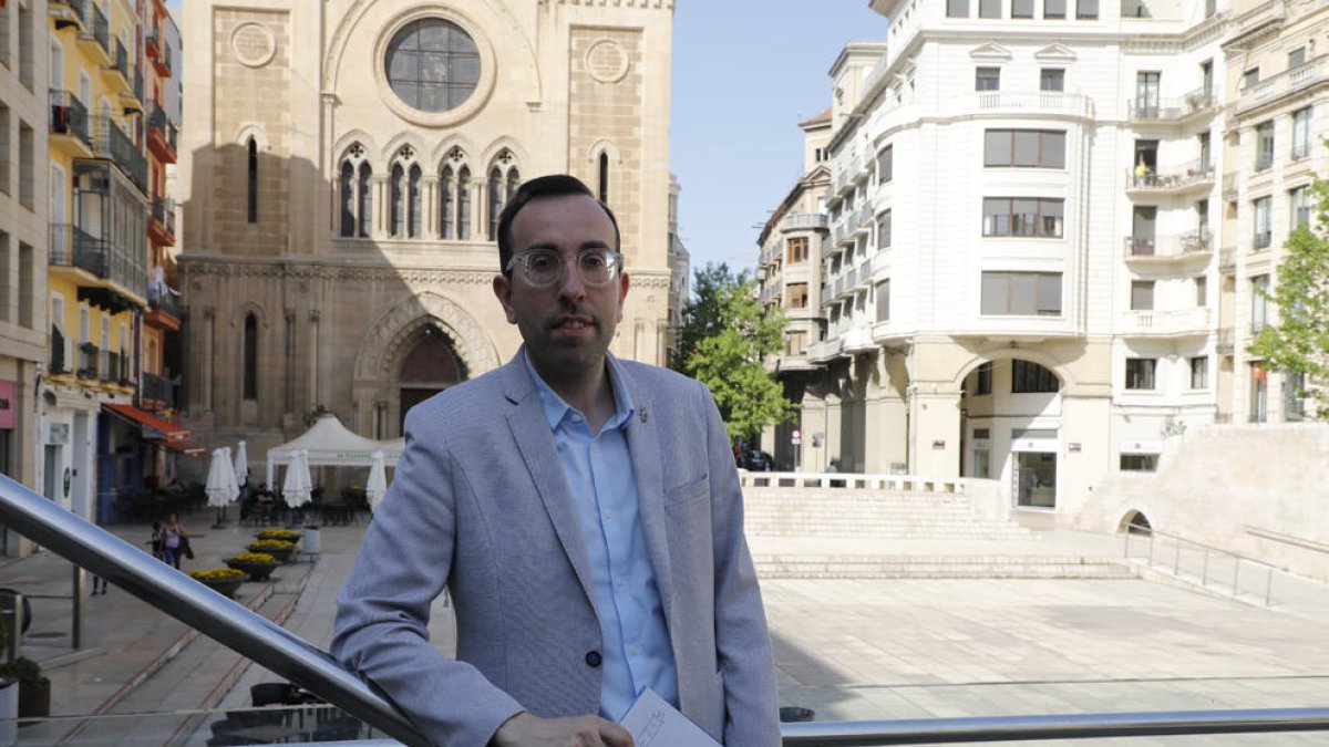 El alcaldable del PP, Xavi Palau, posa con un cartel de su marca, Lleida Implicada, en la plaza Sant Joan.