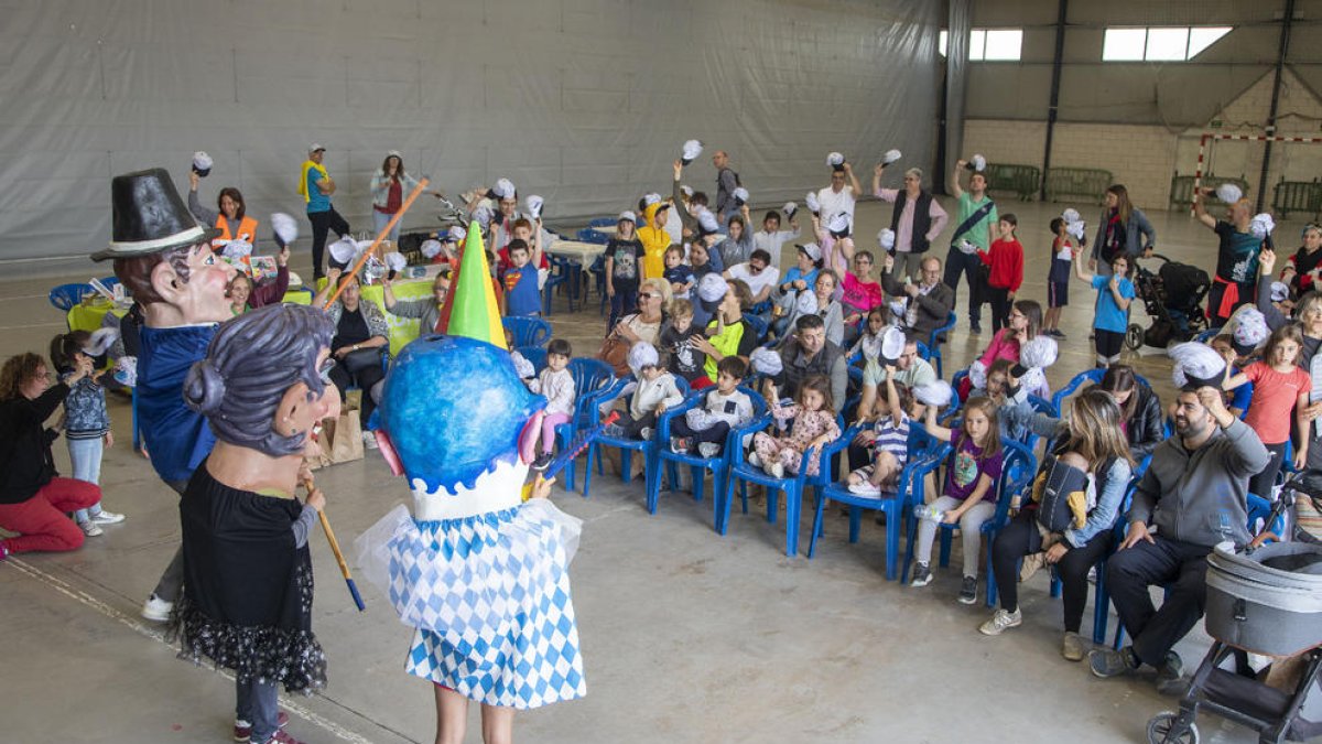 Baile de ‘capgrossos’ con los participantes levantando la gorra en el pabellón.