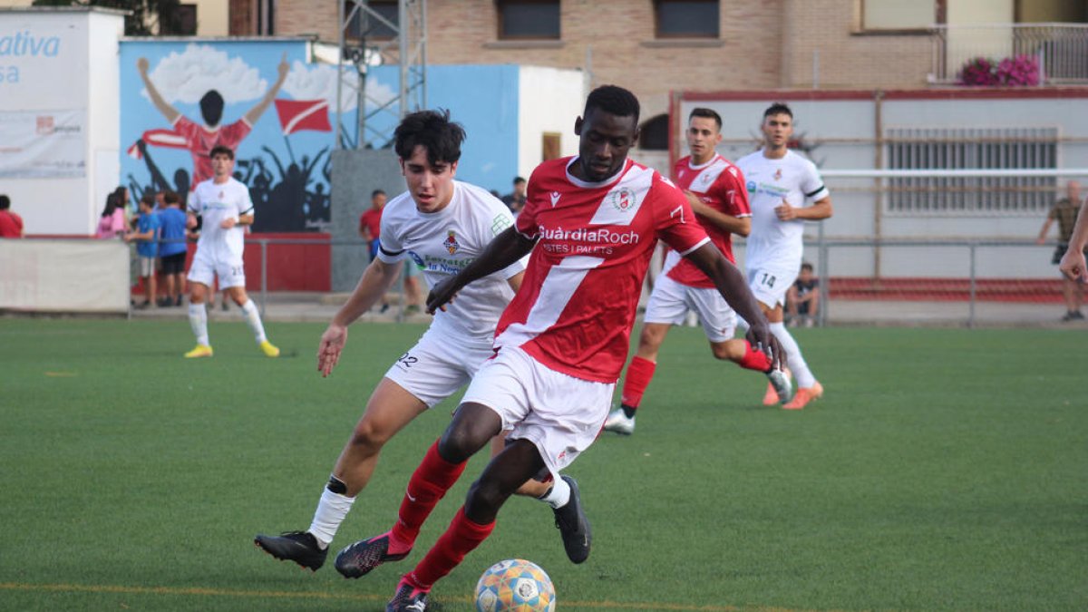 Un jugador de l’Artesa de Segre controla la pilota davant de la pressió d’un del Balaguer.