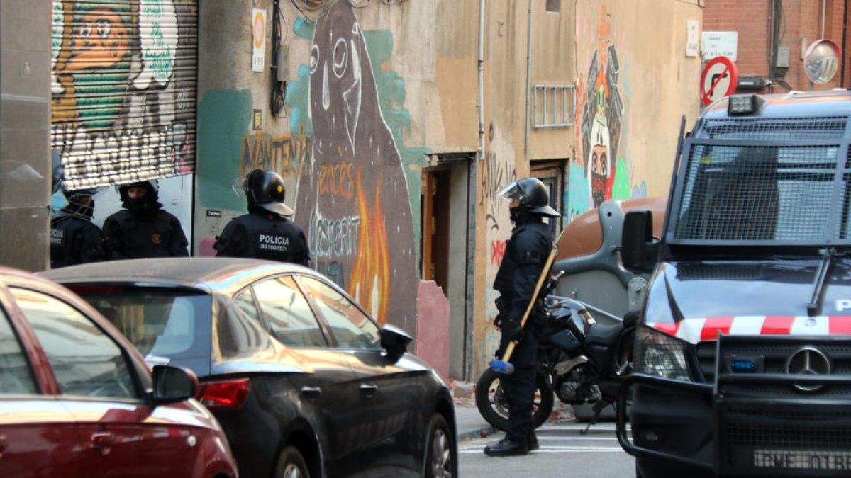 Mossos d’esquadra desallotgen un habitatge okupat a Barcelona.
