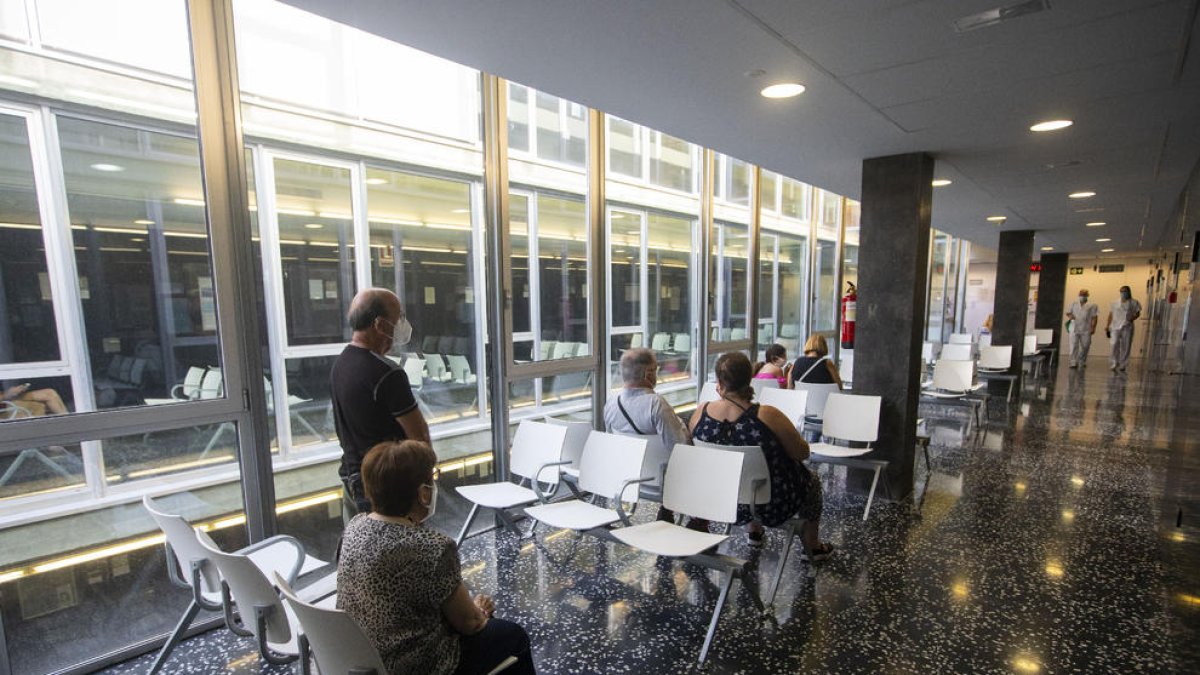 Diverses persones esperen a ser ateses a la sala d’espera del CAP Onze de Setembre.