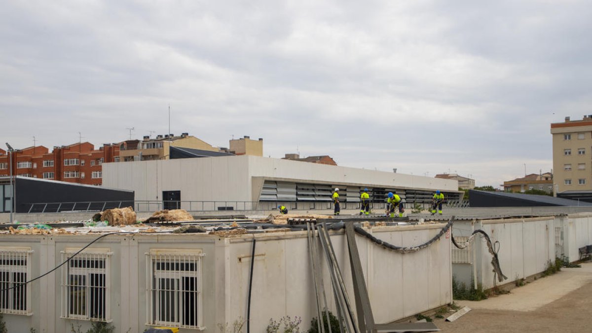 Operarios desmontando la cubierta de los módulos que han formado la escuela Pinyana de Balàfia desde 2009.