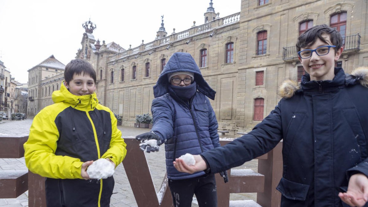 Tres nens jugant ahir a primera hora de la tarda amb la neu que va caure a Cervera.