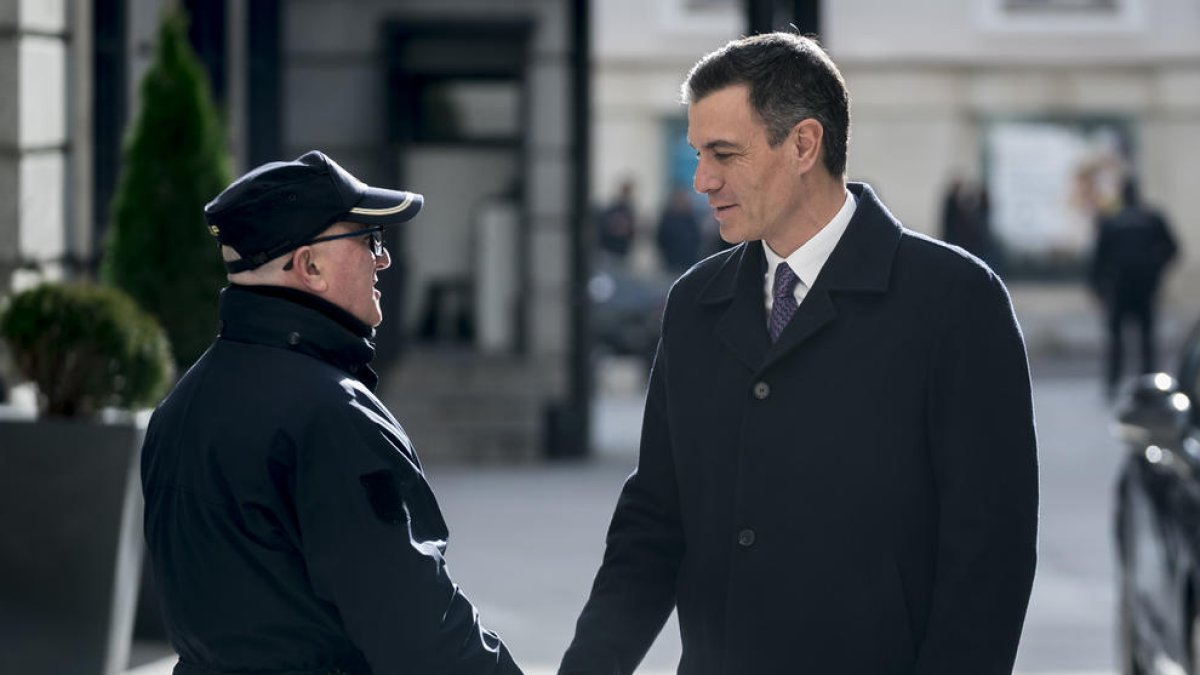 El presidente del Gobierno, Pedro Sánchez, saludando a un guardia ayer a su llegada al Congreso.