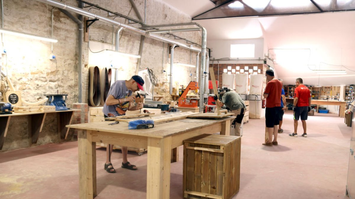 Alguns dels membres del projecte treballant a la nova fusteria social d’Agramunt.