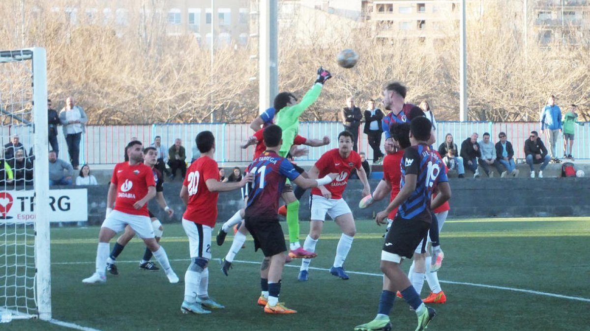 El porter de l’Alpicat evita, amb els punys, la rematada de cap del blaugrana Vargas.