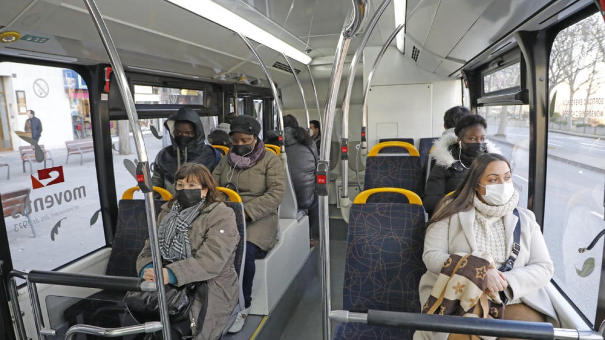 Usuarios de un autobús urbano en Lleida, ayer con mascarilla.