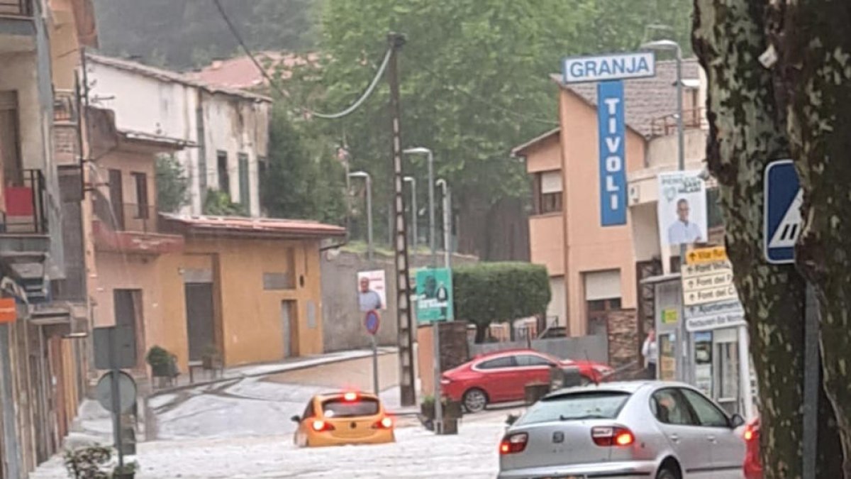 Dos coches que quedaron atrapados por el granizo y la lluvia.