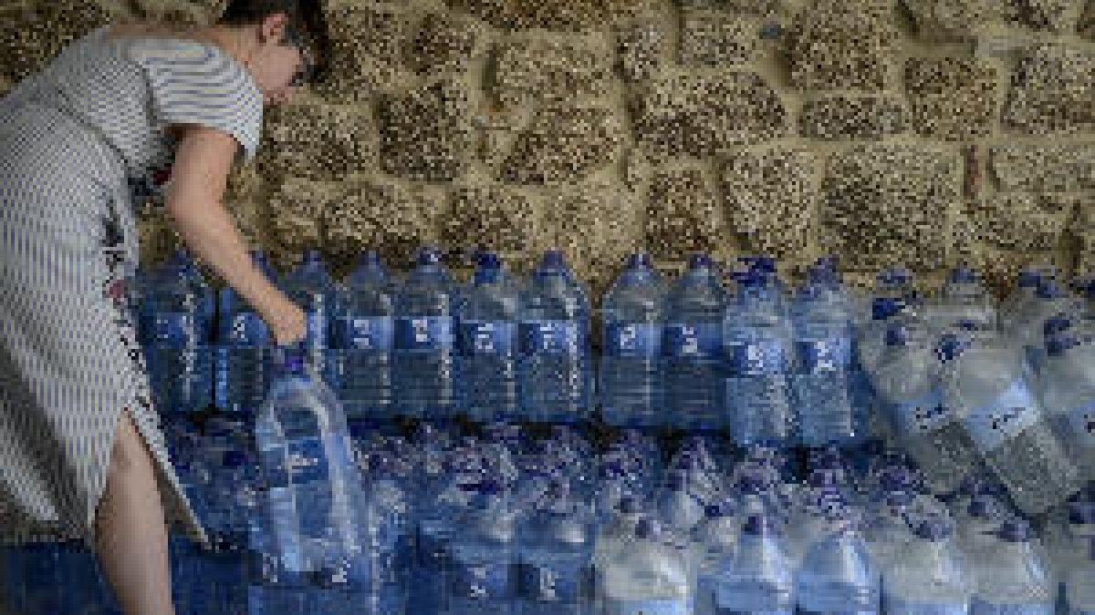 Imagen de archivo de una mujer cogiendo agua embotellada.