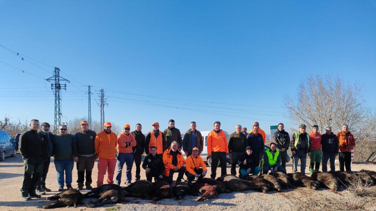Alguns dels participants en la cacera amb els senglars abatuts.