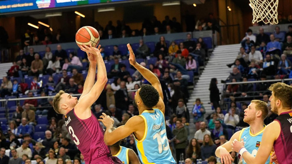 Álex Urtasun llança de forma acrobàtica davant de l’oposició de Sean Smith.