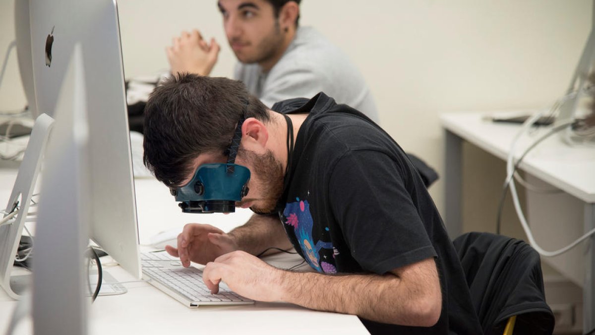 Un alumno navega por internet con gafas que simulan baja visión.