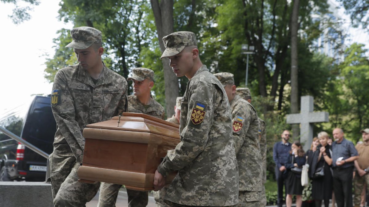Soldados ucranianos cargan en Kyiv el féretro durante el funeral de un militar caído en combate.