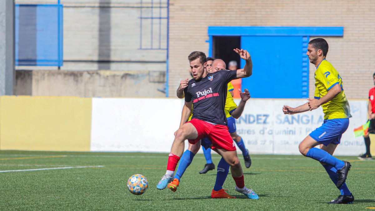 Jofre Graells intenta controlar una pilota davant la pressió de dos rivals del San Mauro.