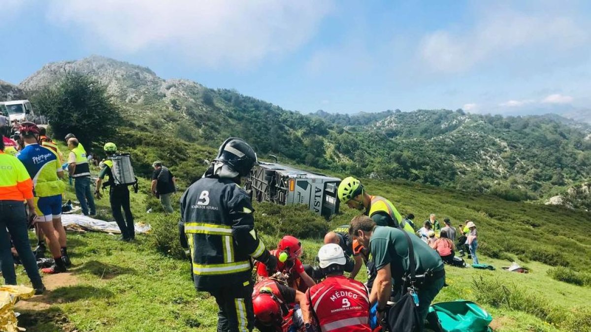 Efectius del SEPA atenen a una de les ferides en el tomb d'un autobús en la pujada als Lagos de Covadonga.