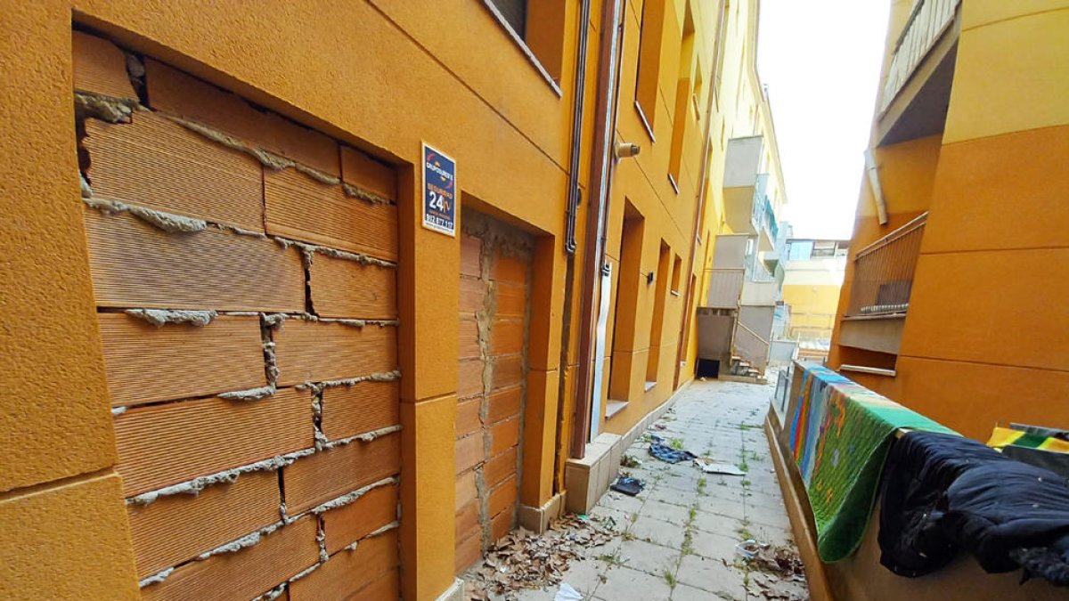 Habitatges amb les portes i finestres tapiades al bloc de pisos Santiago Rusiñol de les Borges.