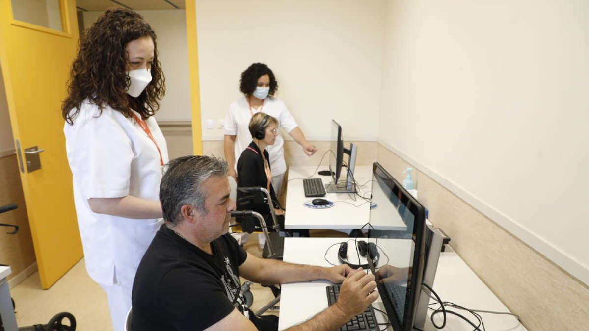 Pacientes haciendo ejercicios cognitivos en un ordenador del Centro Miquel Martí i Pol de Lleida.