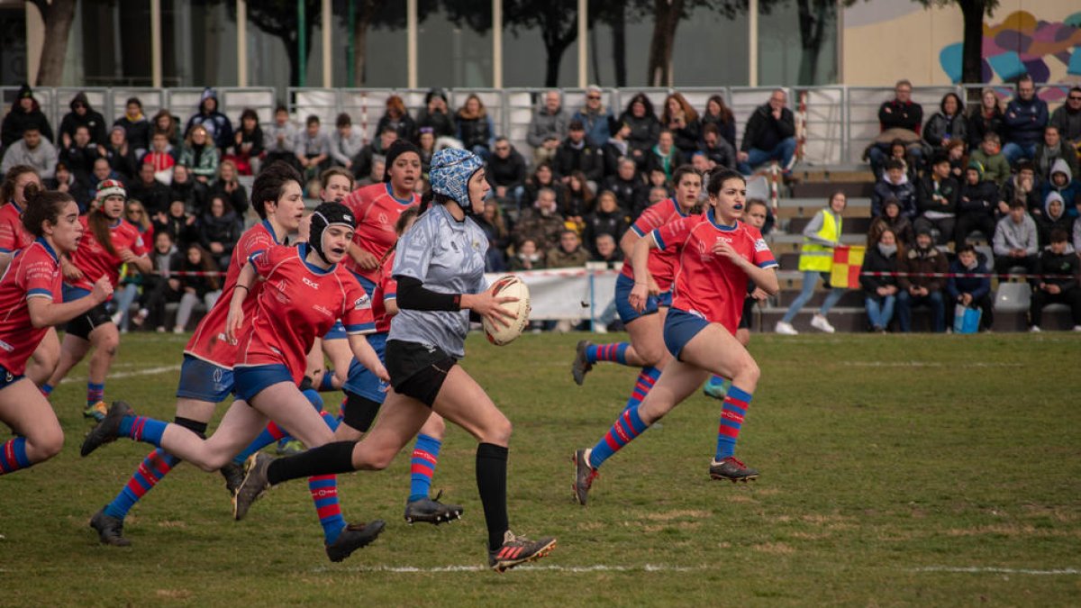 De gris, Ariadna Monreal, que juega en el Inef Lleida, corre con el balón perseguida por rivales.