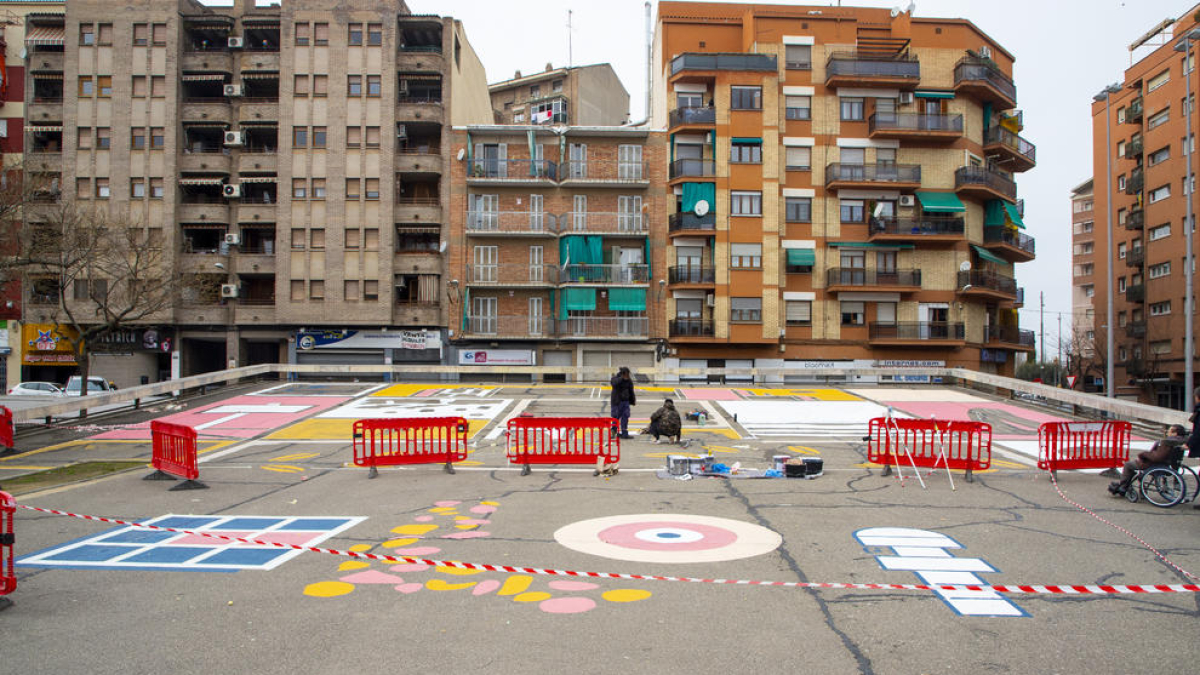 Vista general del mural que estan pintant al paviment de la plaça del Clot de les Granotes.