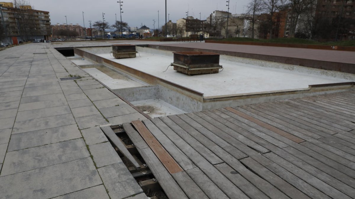 Pavimento en mal estado. Una parte de las baldosas de madera del cubrimiento de las vías, entre la calle Rosa Parks y Prat de la Riba, están levantadas y en mal estado.