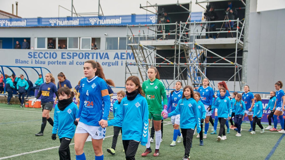 Nadia, amb dos jugadores de la base, en el partit davant del Barça B.