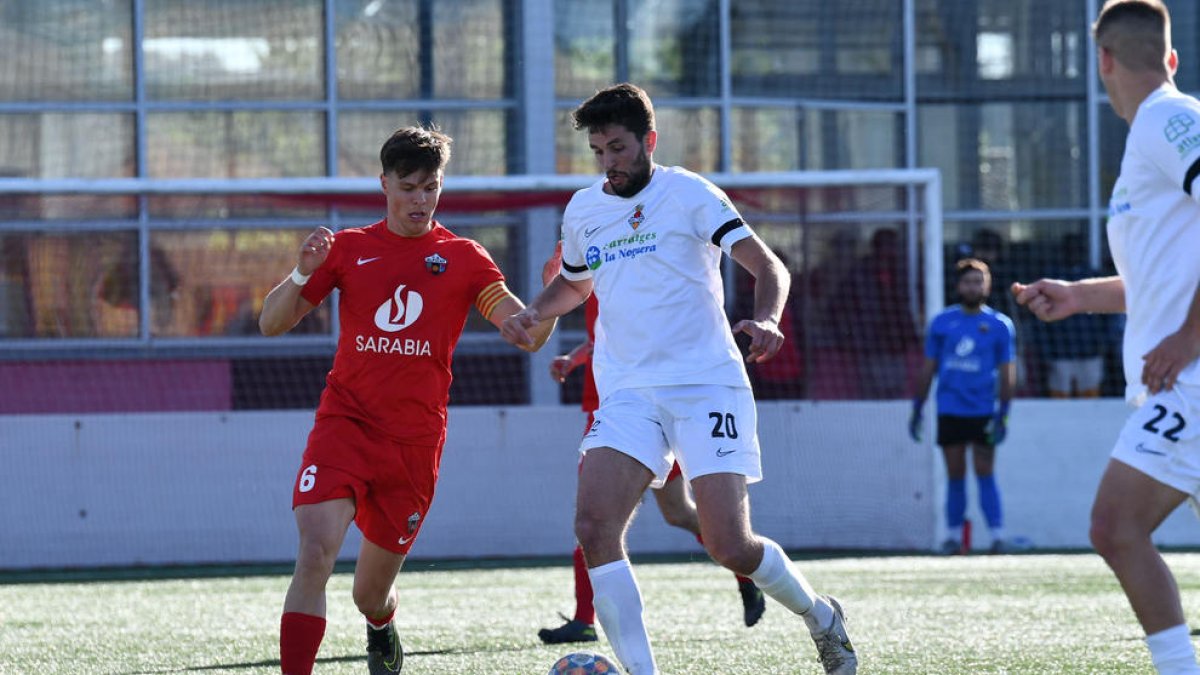 Pau Solanes, del Balaguer, controla la pilota ahir davant la pressió d’Alfa, capità de l’Alpicat.