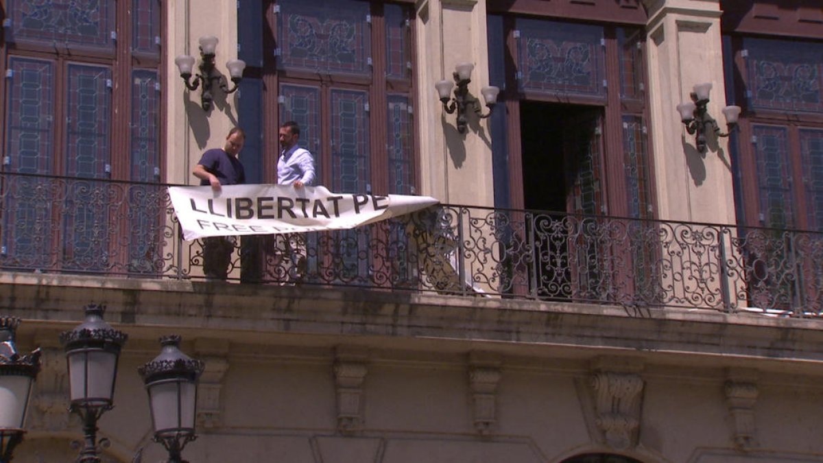 A dalt, el moment de retirada de la pancarta del balcó que dona a Blondel, i a baix, ja sense.