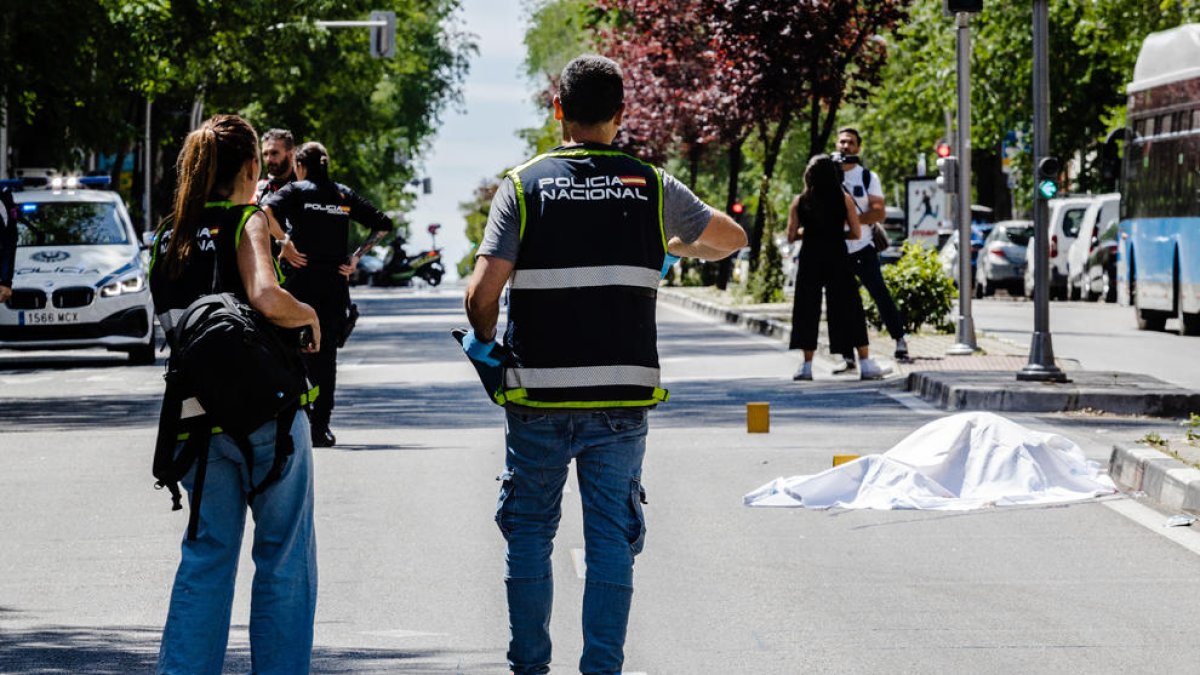Agents de la policia custodien el cos d’una de les víctimes.