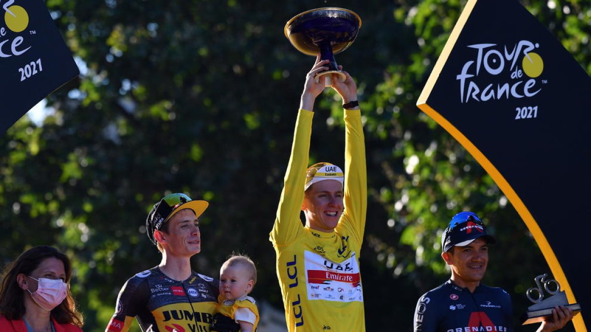 Tadej Pogacar, flanquejat al podi de París per Jonas Vingegaard i Richard Caparaz.