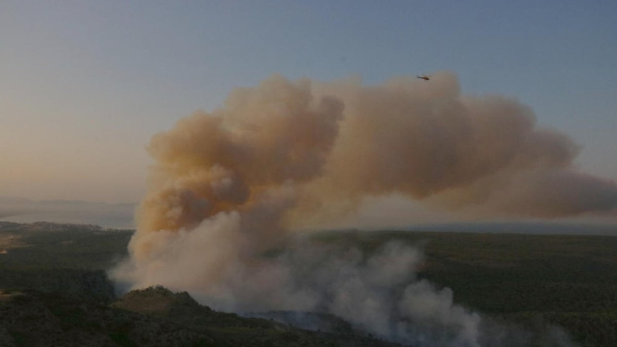 Un helicóptero sobrevolando ayer la zona del macizo del Montgrí afectada por el incendio.