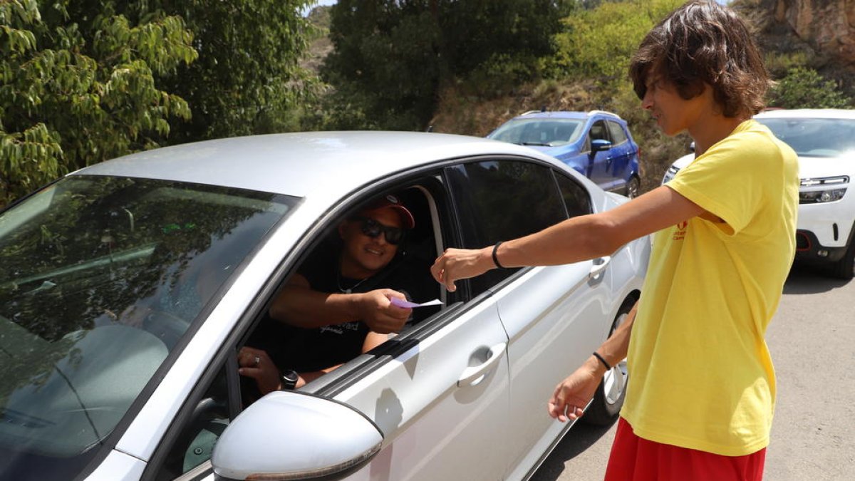 Un vigilant controla l’entrada de vehicles a la zona de la Platgeta de Camarasa i cobra cinc euros.
