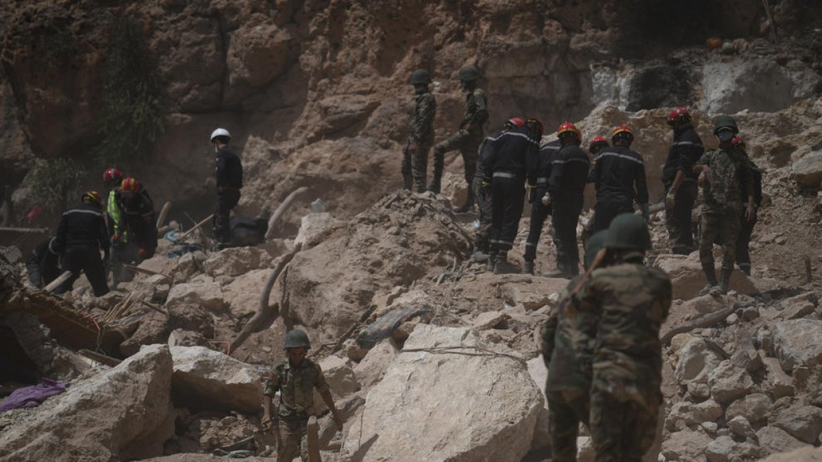 Bomberos buscan supervivientes entre los escombros en la aldea marroquí de Imi N’Tala.