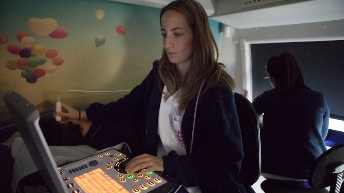 Una sanitaria haciendo una prueba médica al Bus de la Salut.