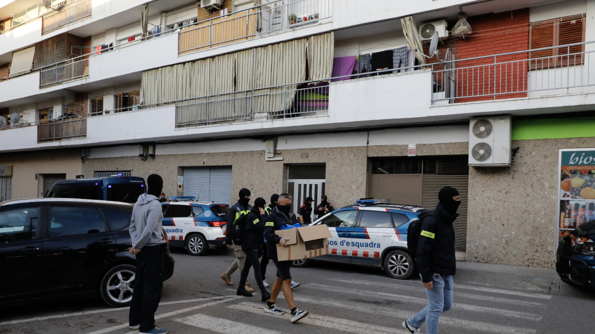 Els investigadors amb el material que van decomissar al domicili dels detinguts. - AMADO FORROLLA