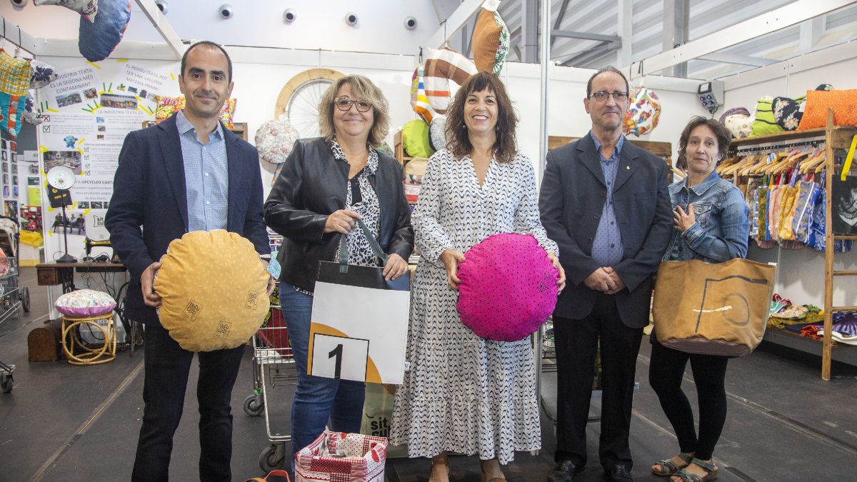 Les autoritats, a l’estand de Cartaes de la 23 Fira del Medi Ambient deTàrrega , que ha elaborat 200 bosses amb pancartes reciclades. - LAIA PEDRÓS