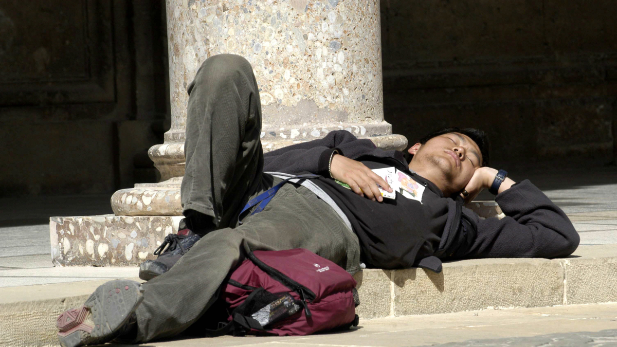 Imagen de una persona descansando en una vía pública