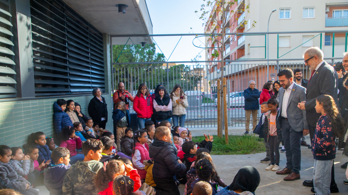 El president de la Generalitat y el alcalde de Lleida, saludando ayer a alumnos del colegio Minerva, en Balàfia. - GERARD HOYAS