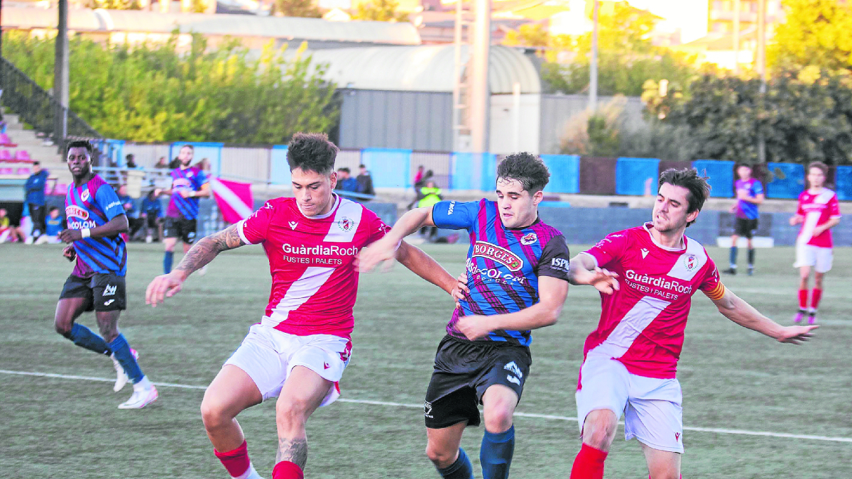 Un jugador del Tàrrega pugna amb dos rivals de l’Artesa de Segre pel control de la pilota. - XAVIER SANTESMASSES