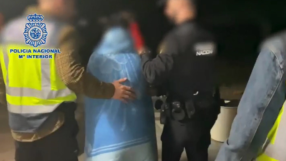 Agentes de la Policía Nacional junto a la madre en el momento de su detención.