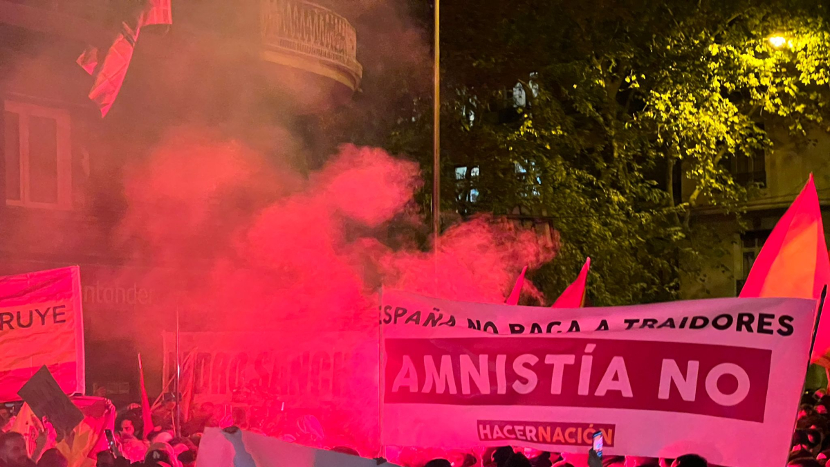 Pancartas contrarias a la amnistía rodeadas de humo