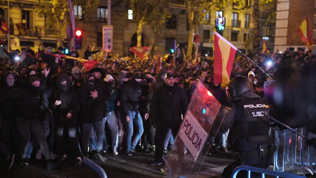 Decenas de manifestantes con banderas se enfrentan a la Policía, en la sede del PSOE en la calle Ferraz de Madrid.