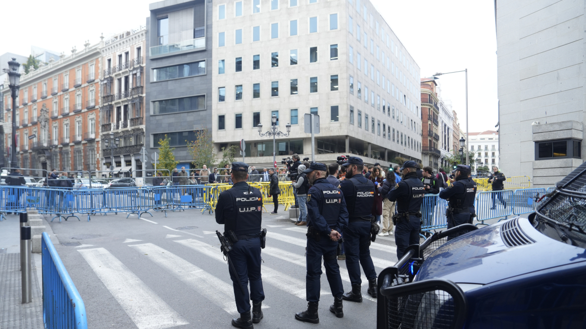 Varios agentes de la Policía Nacional delante de las vallas metálicas que blindan el Congreso de los Diputados.