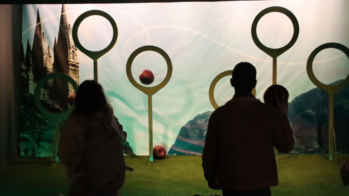 Dos personas juegan a Quidditch en la muestra interactiva 'Harry Potter: The Exhibition' en Barcelona.